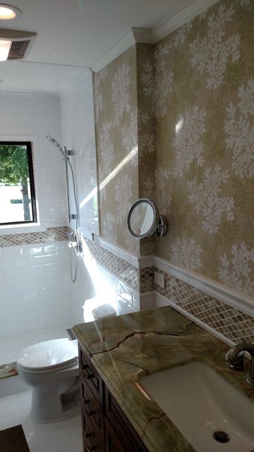 Remodeled bathroom with wall-mounted mirror and granite countertop on vanity.