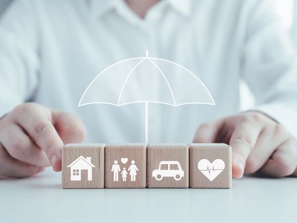 A person with an umbrella icon over four wooden blocks.