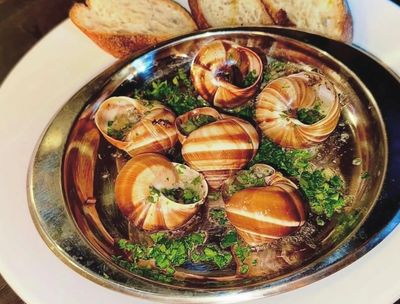 Plate of escargots with herbs and bread.