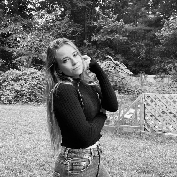 Young woman posing thoughtfully outdoors in black and white.