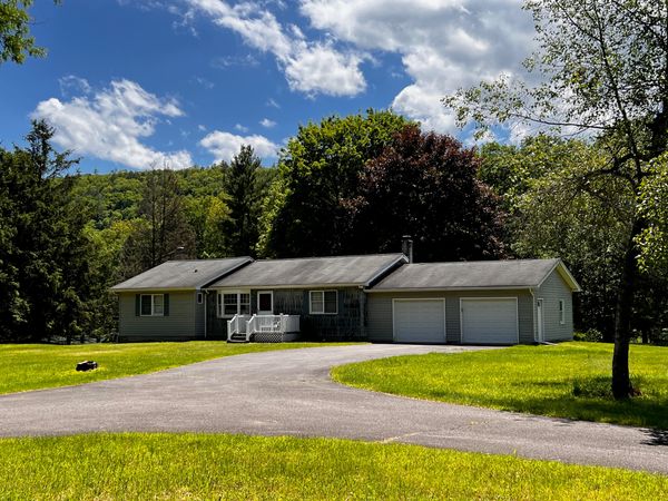 Suburban house with lush lawn under a partly cloudy sky.