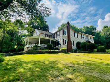 A large house with a spacious lawn and trees.