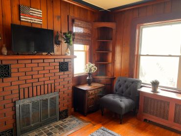 Cozy living room corner with fireplace and armchair.