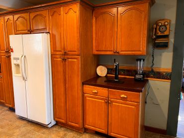 Kitchen with wooden cabinets and white refrigerator.