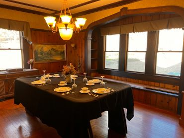 Cozy dining room with black tablecloth and wooden walls.