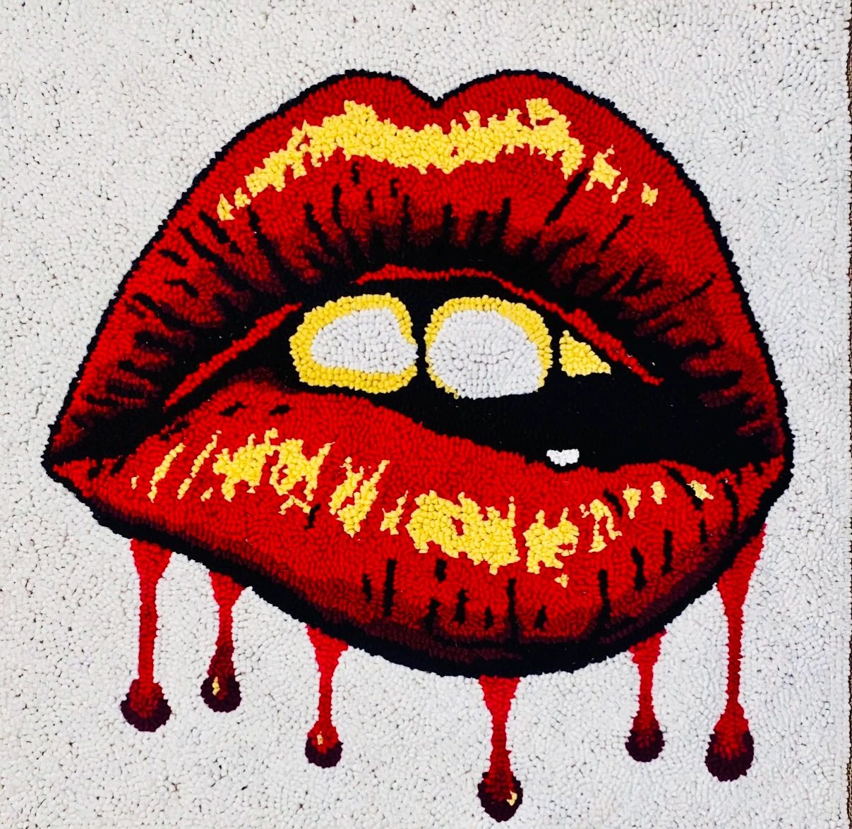 Red lips parted with red drips along the bottom lip.