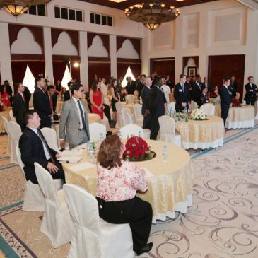 Formal event with attendees seated at round tables.