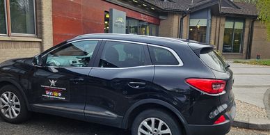 Black compact SUV parked near buildings.