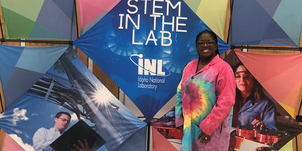 Person in a colorful lab coat at Idaho National Laboratory STEM event.