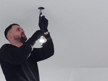 Ein Mann installiert eine Glühbirne in der Decke.
