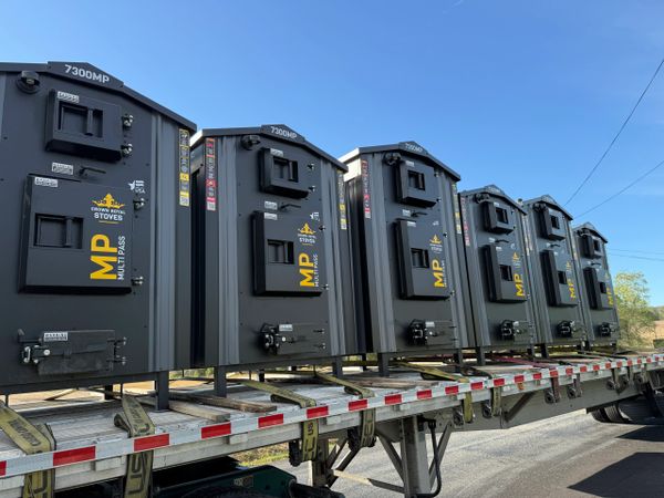 Row of black Crown Royal MP 7300MP stoves loaded on a flatbed truck.