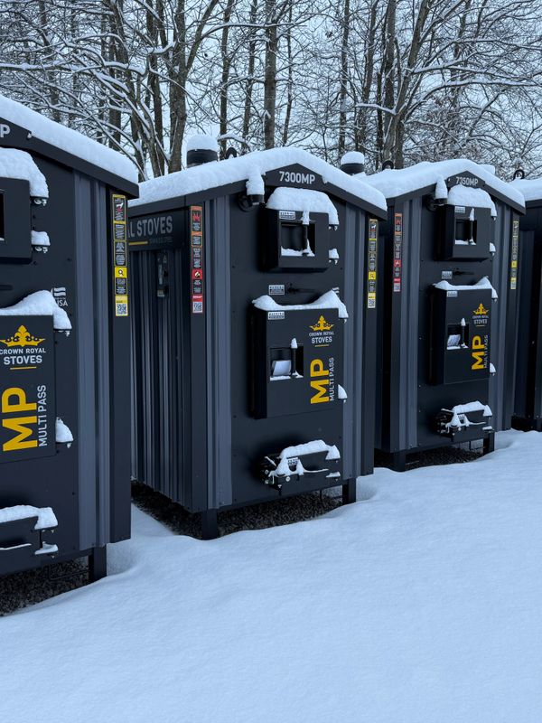 Snow-covered Crown Royal stoves lined up outdoors in a winter setting.