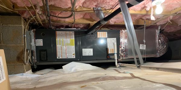 HVAC system installed in a basement with exposed insulation and ductwork.