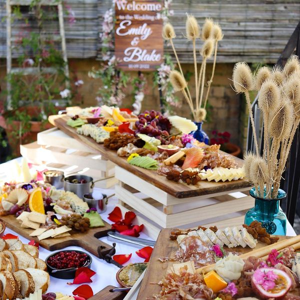 Elegant wedding charcuterie boards with flowers and dried plants.