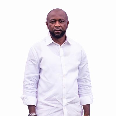 Man wearing a white shirt standing against a white background.
