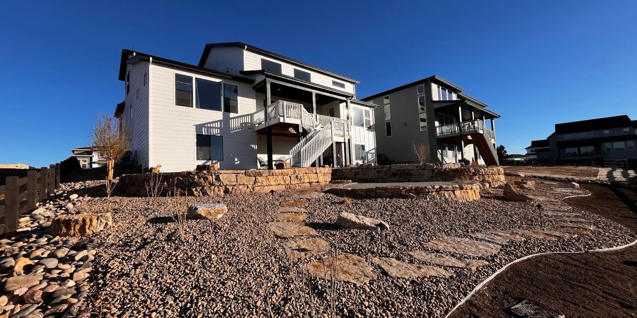 Modern houses with stone patios on a clear day.