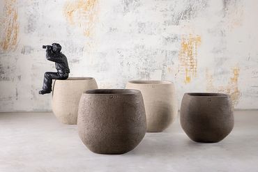 Three rounded textured planters in natural stone tones.