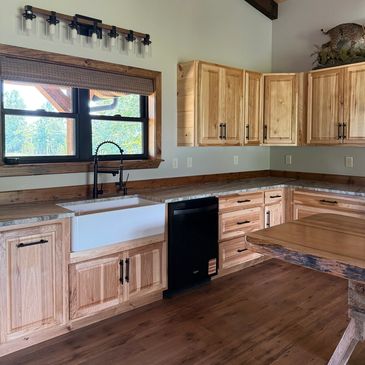 Rustic kitchen with wooden cabinets and farmhouse sink.