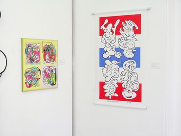 Abstract colorful paintings with intricate, swirling patterns hang on white gallery walls.