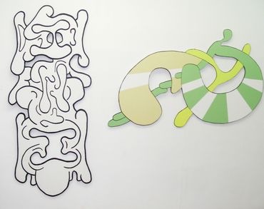 Abstract wall art with organic shapes in black and pastel colors.