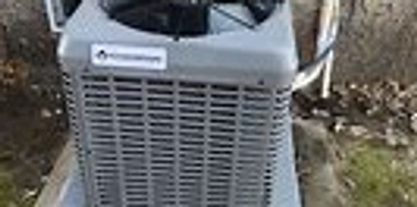 Outdoor air conditioning unit installed on a concrete slab beside a house. used for heating and cooling.