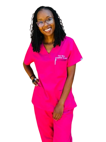 Smiling woman in bright pink scrubs with glasses and a smartwatch.