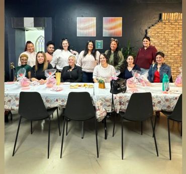Group of women posing at a decorated table indoors.