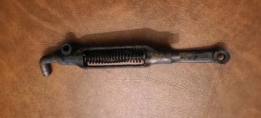 Close-up of a metal spring-loaded latch on a brown surface.