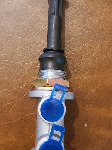 Industrial valve with blue caps on a brown surface.