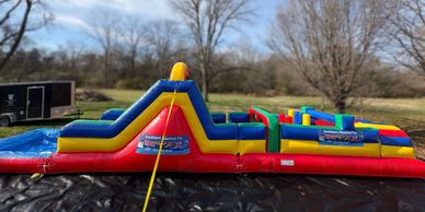 Colorful inflatable obstacle course set outdoors on a sunny day.