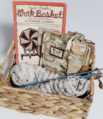 Woven craft basket filled vintage Workbasket magazine, junk journal folio, yarn, & knitting needles