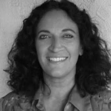 A smiling woman with wavy black hair