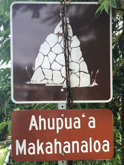 Sign reading 'Ahupuaʻa Makahanaloa' with a rock pile symbol.