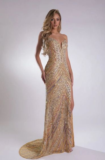 A woman in a shimmering gold sequin gown with a slit and long wavy hair.