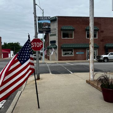 American flag near a stop sign on a small-town street corner.