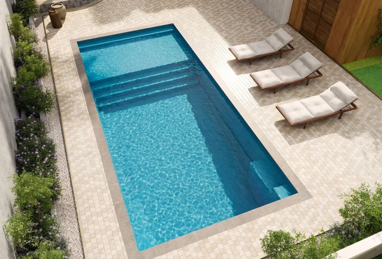 Modern backyard with a clean rectangular pool and three cushioned lounge chairs.