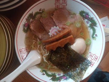 Bowl of ramen with pork, egg, seaweed, and noodles.
