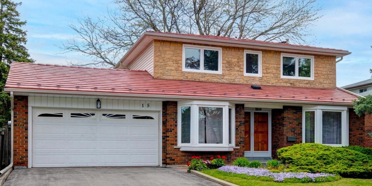 A two-story suburban house with a brick facade and a red roof.