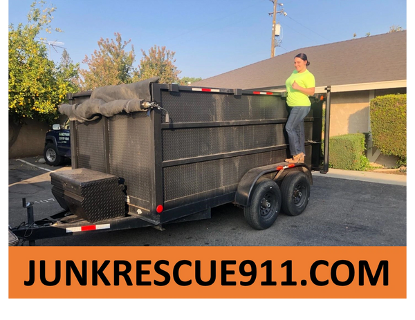 Junk Removal worker standing next to trailer. Junk Removal Fresno
