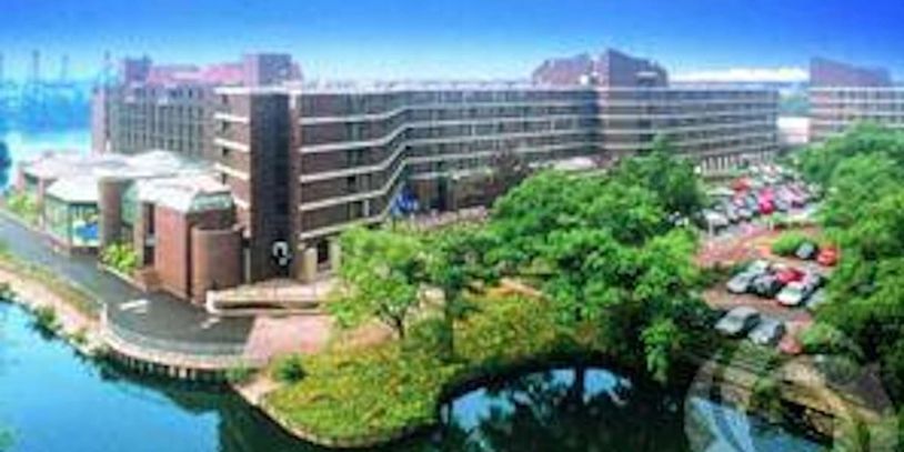 A large building complex near a water body with surrounding greenery and a parking lot. Hilton Birmingham Metropole, close to Birmingham International Airport and Birmingham International Station