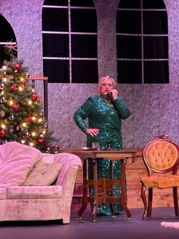Woman in a green sequined dress talking on a vintage phone in a festive living room.