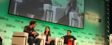 Three people on stage at TechCrunch Disrupt event discussing technology.