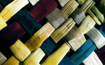 Close-up of colorful woven wooden strips in a basket pattern.