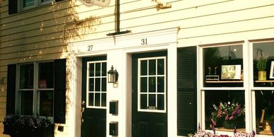 Two adjacent house doors numbered 27 and 31 with plants outside.