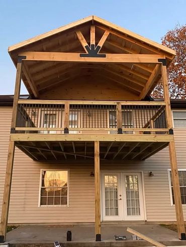 Two-story wooden deck with a covered upper level on a house.