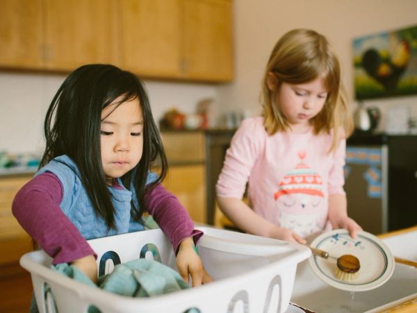 Two children doing household chores in the kitchen.