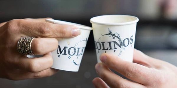 Small paper cups with the logo of Molinos Coffee