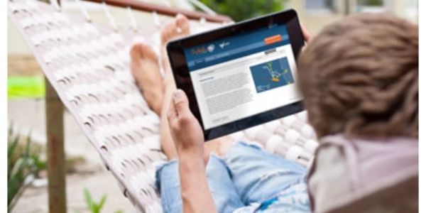 Person relaxing on a hammock using a tablet.
