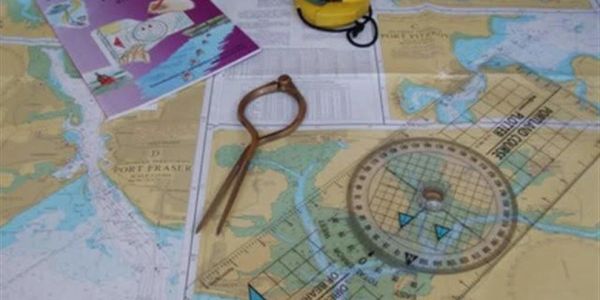 Map with navigation tools and a book.
