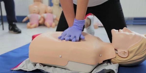 Person performing CPR on a medical training mannequin.